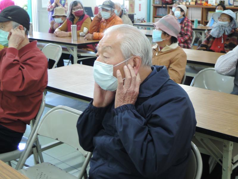 三灣長輩跟著聽力師一起用健耳操按摩耳朵