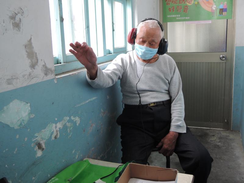 學員戴著耳機進行聽力檢測，聽見聲音舉起手來