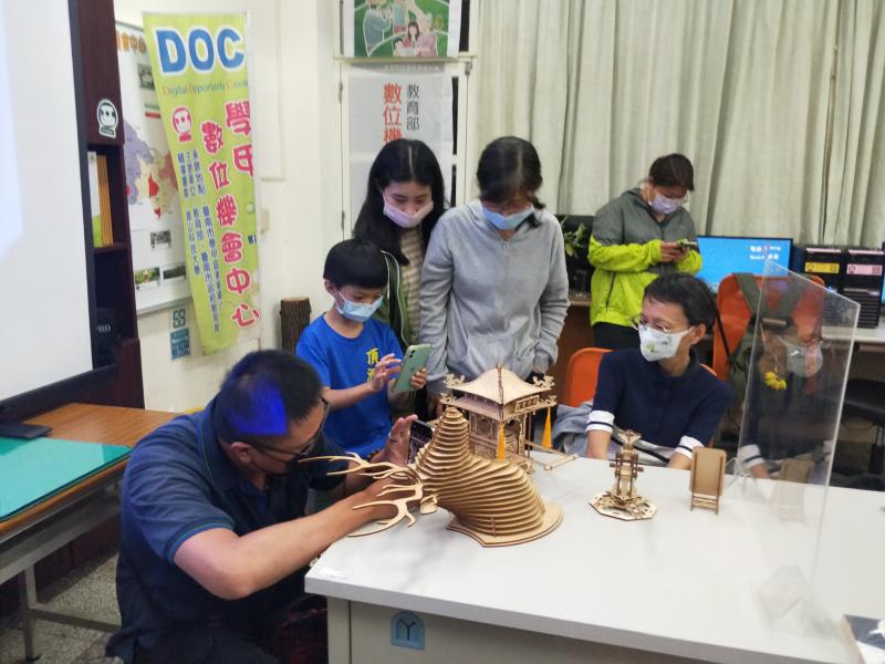 學員看雷雕機竟然可以雕出這些精細的轎子，也能做出小朋友的玩具，都拿出手機拍照