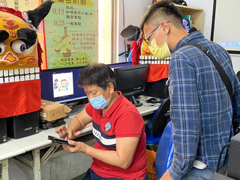 學員使用手機製作貼圖，助教在一旁協助指導