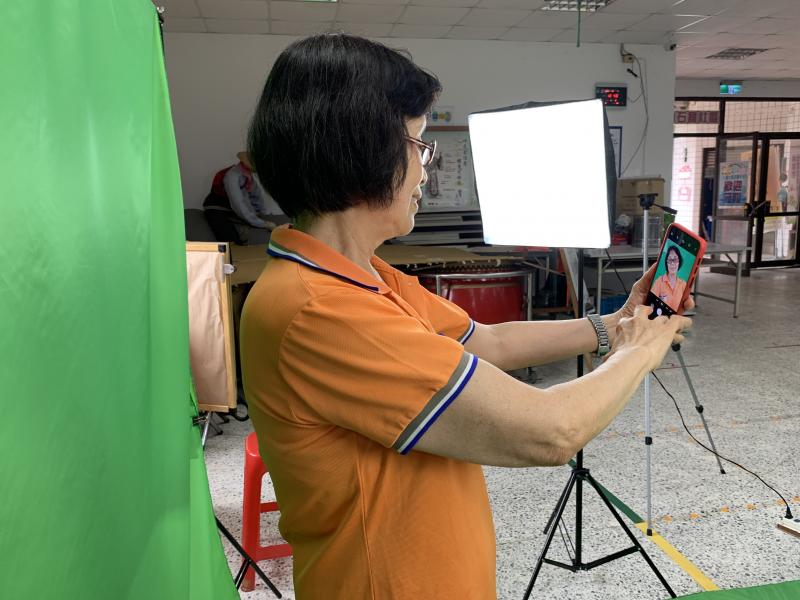 架設布幕背景，學員先用手機自拍一張練習