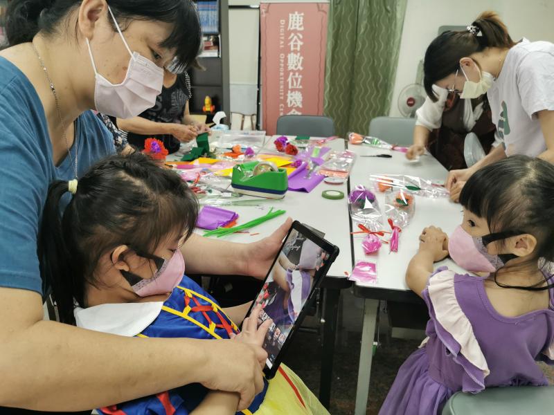 ​​​​​​​經過老師教學，家長帶著小朋友一起學習操作平板，也使用上課教學來拍攝並完成母親節創意貼圖，照片中小朋友有模有樣的挑選喜歡的搭配