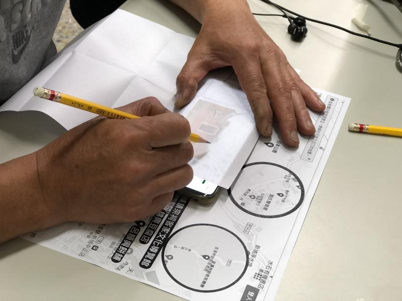 同學在手機上以描圖紙繪製地圖