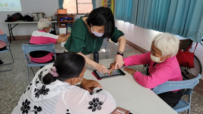 老師親自帶長者手指操作平板情形。