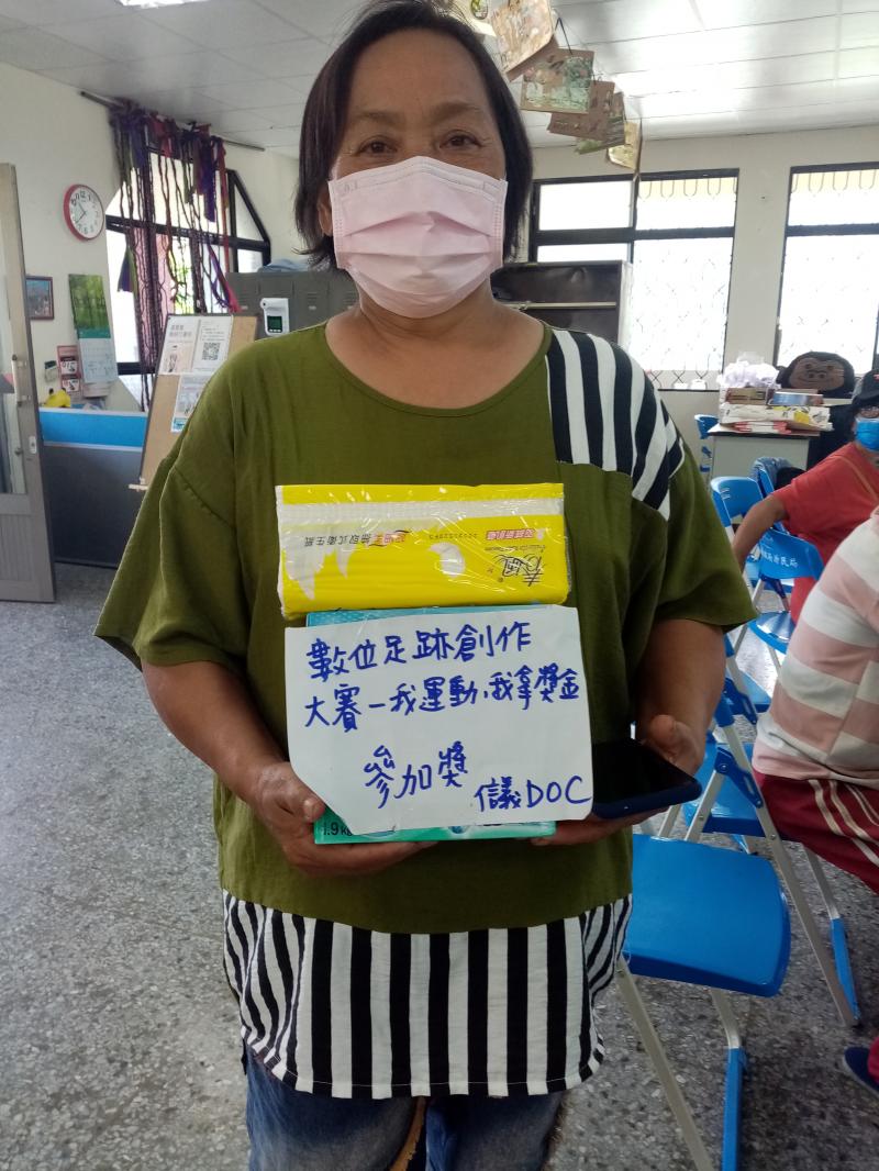 學員拿著參加獎洗衣粉及衛生紙拍照