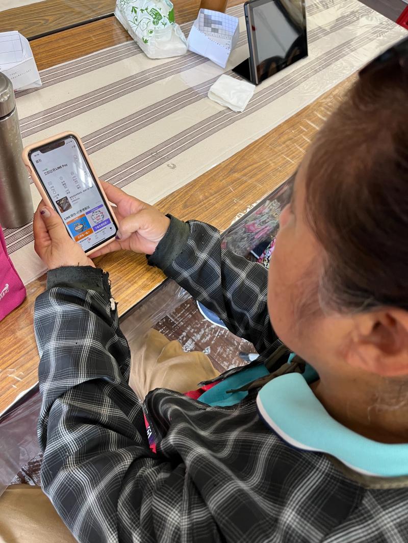 在地婦女跟著講師一起使用LINE錢包。