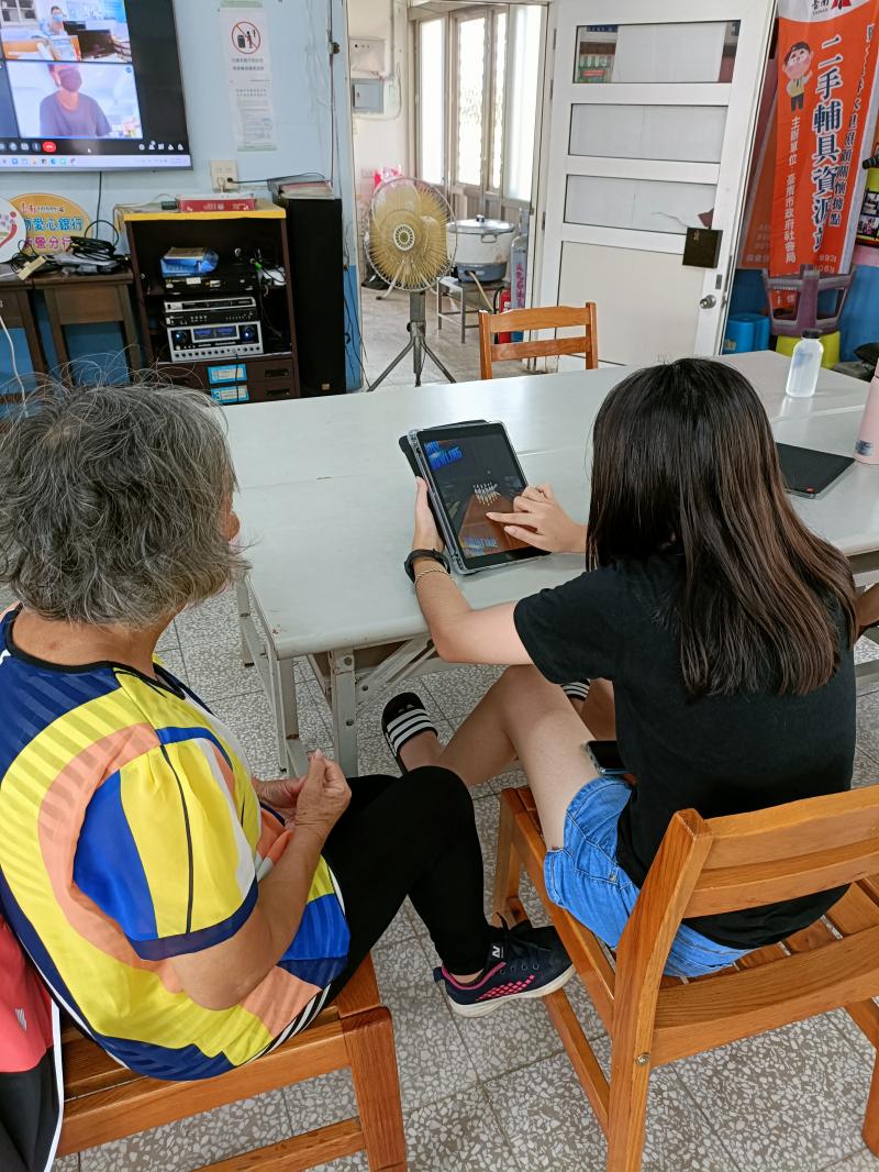 老師教完如何用平板下載遊戲 APP, 祖孫一起體驗遊戲