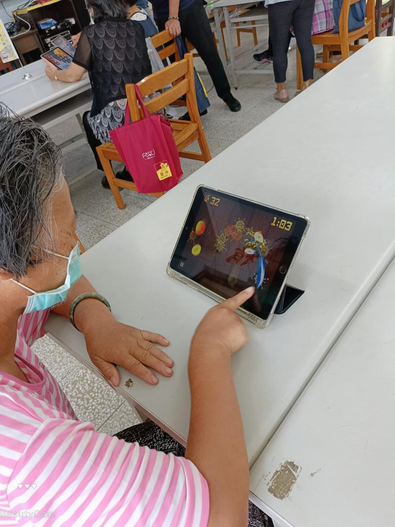 老師教完如何用平板下載遊戲 APP, 阿嬤體驗遊戲玩得很開心