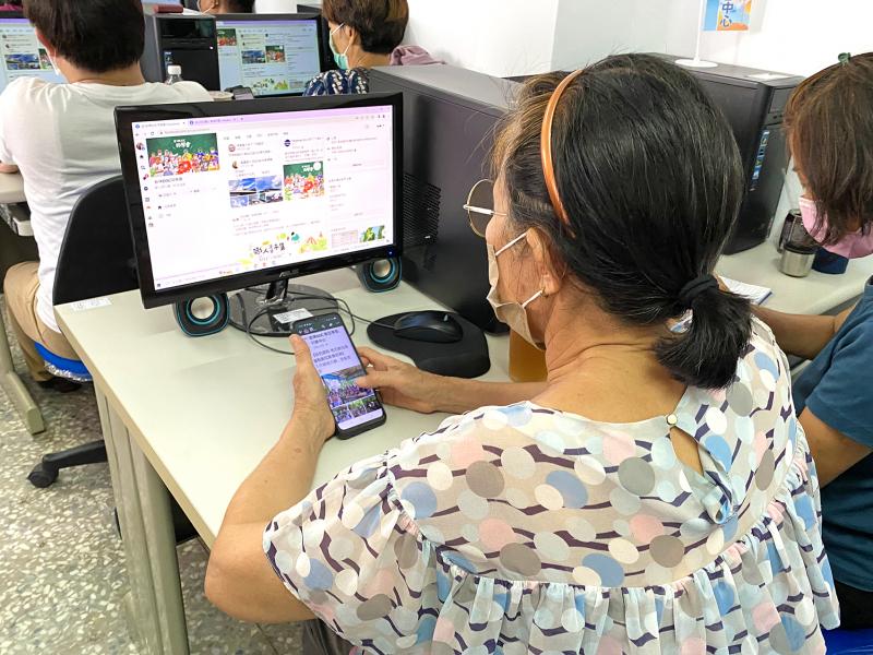 學員一邊認真看著電腦講師操作畫面，一邊拿手機認真練習臉書社團操作