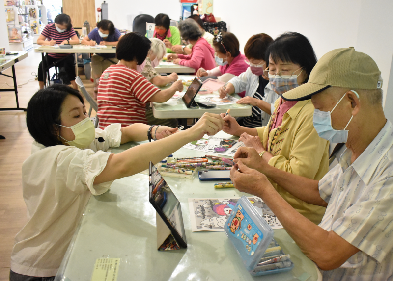 講師協助學員用蠟筆著色