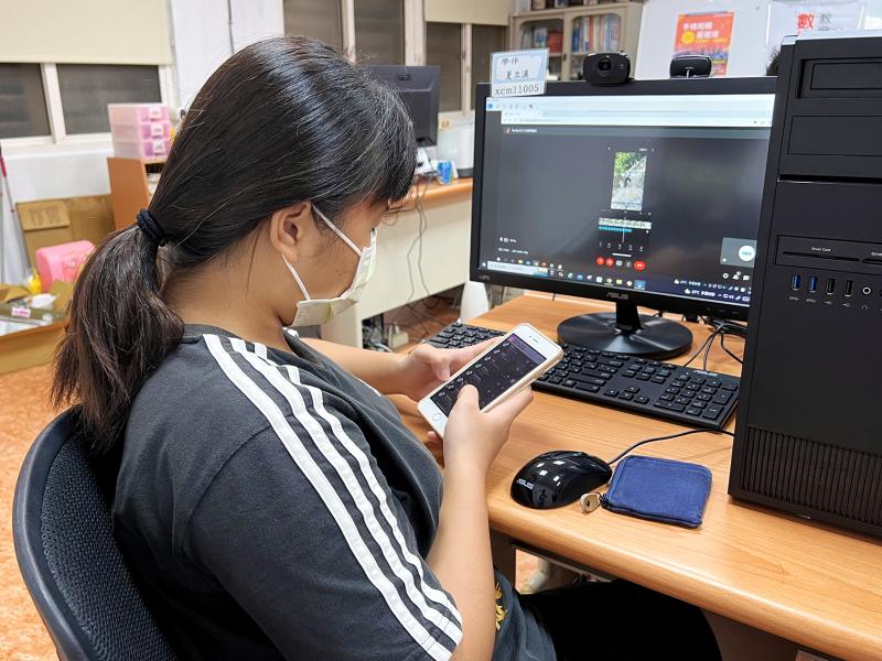 學員使用手機操作剪輯軟體，將影片置入配樂