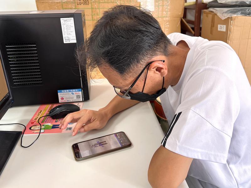 學員專注的看著手機，認真製作家人專屬貼圖