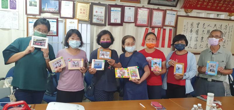 學員們興高彩烈興拿起明信片成果與老師拍照.