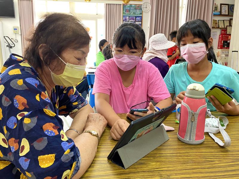 小孫女們用心指導阿嬤操作平板