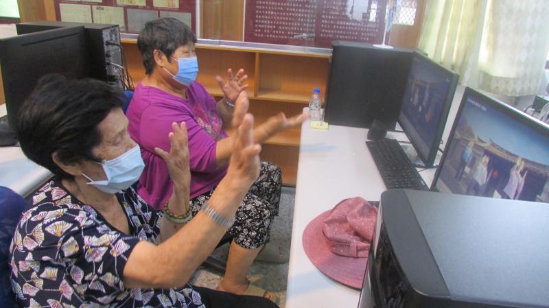 講師播放高齡健康操的影片，請學員跟著影片伸展肢體動作，學員做了大約5分鐘就累得氣喘吁吁，嘴上雖然喊著說好累，可是透過他們的笑聲可以知道他們都很開心。