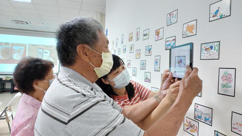 阿公、阿嬤很認真學翻拍照片