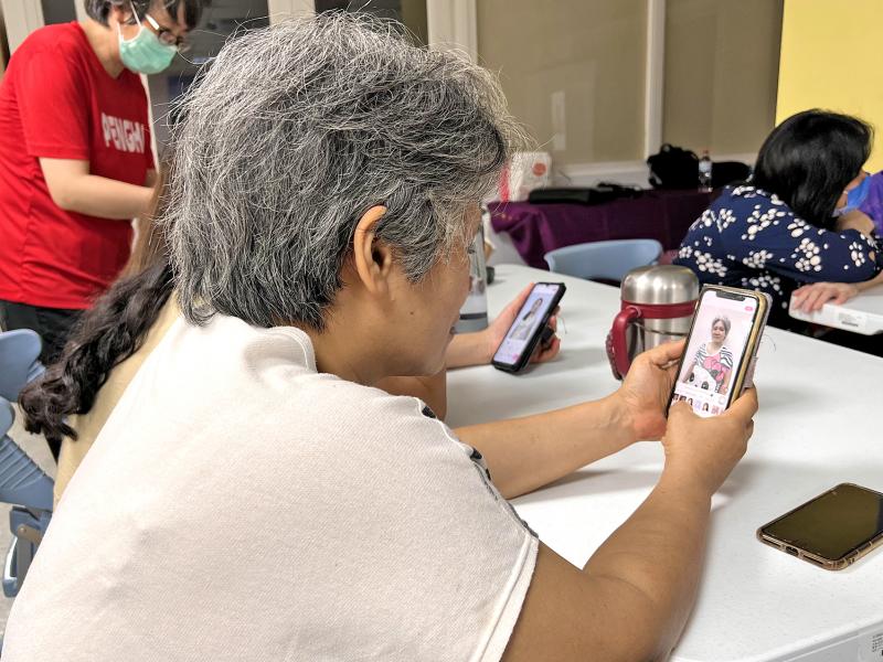 學員拿手機使用App認真練習操作修圖