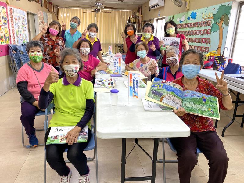 銀髮學員們手拿繪本，開心大合照