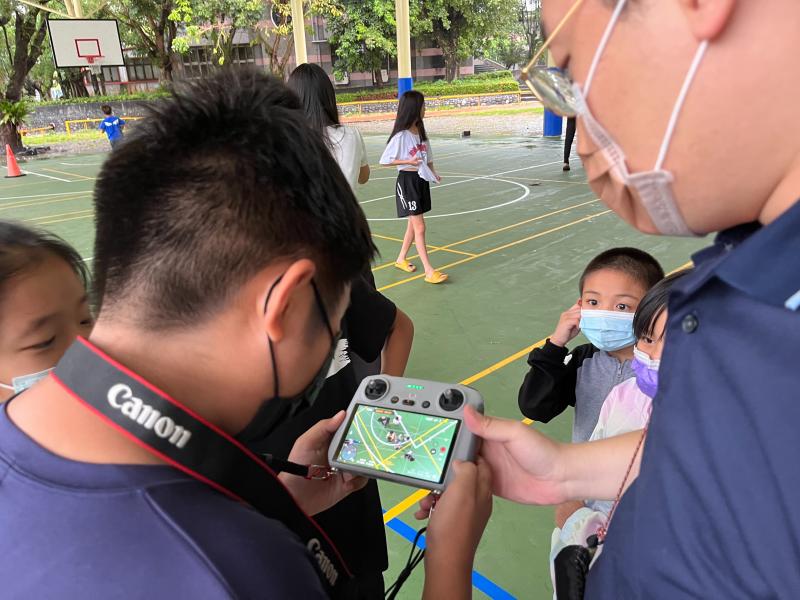 講師現場指導小孩們如何操作空拍機。