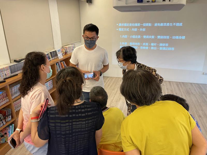 大家圍過來，講師說明拍攝時的技巧