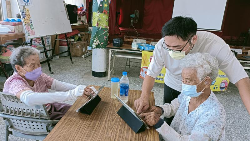 林建穎老師細心教導阿嬤熟悉平板操作