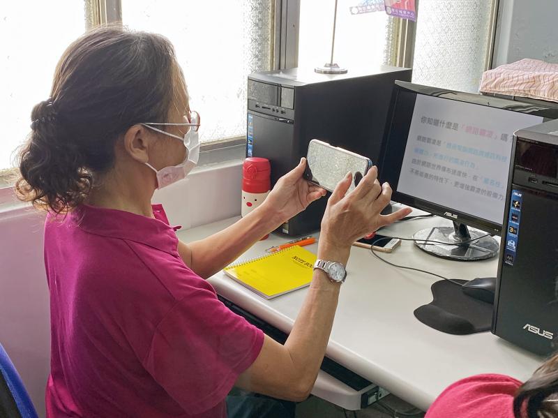 學員一邊專注聽課，一邊使用手機拍攝記錄課程簡報