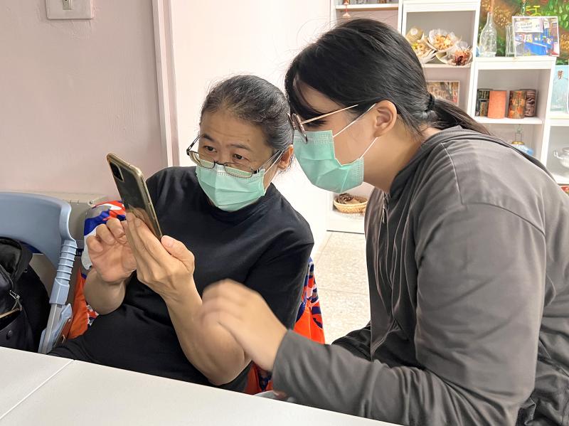 母女倆一起認真看著手機,研究如何使用假訊息過濾平台