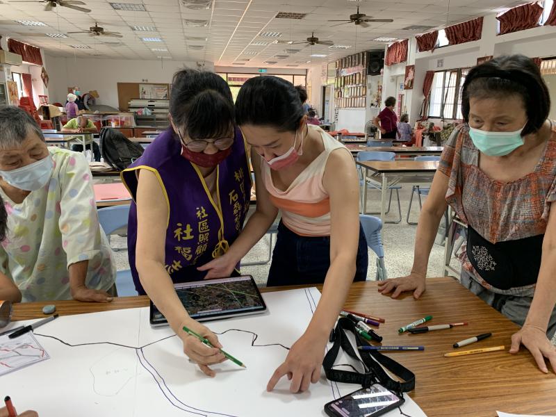 老師帶社區使用平板電腦查詢google map從空中看石磊，並劃出每條街道