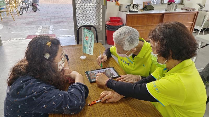 講師協助指導長輩尋找圖樣上細微處進行填色