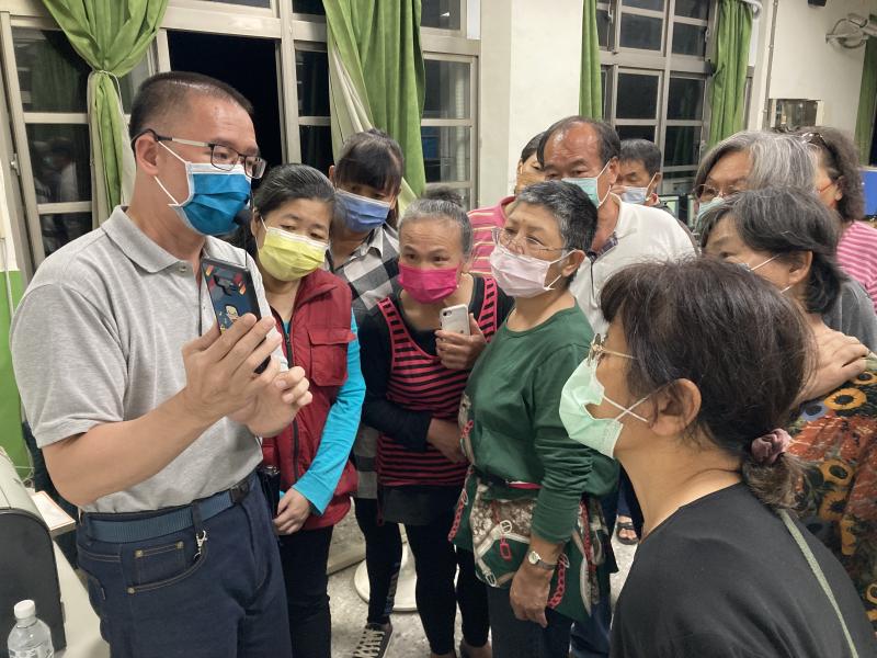 老師教導學員利用APP掃描軟體來將舊相片數位化