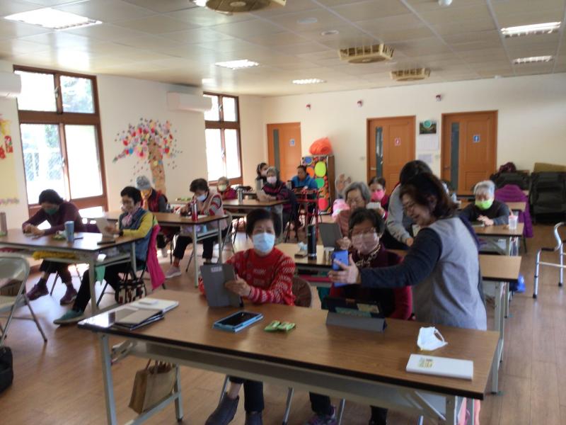 學員使用手機查詢相關假新聞訊息並與同學相互研究交流