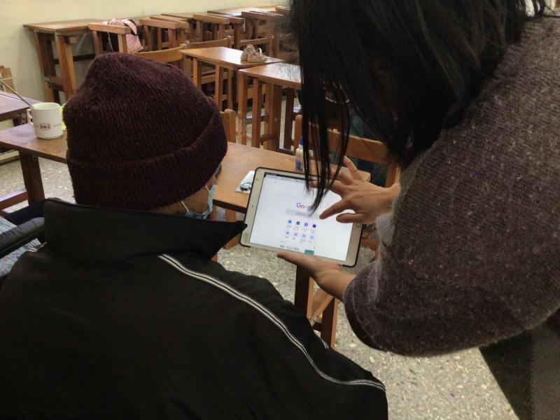 講師拿平板向學員解說操作