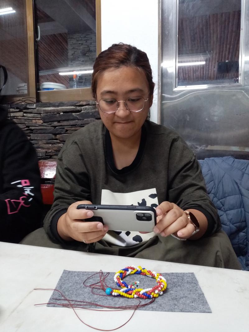 學員拿著手機操作美圖秀秀進行拍照