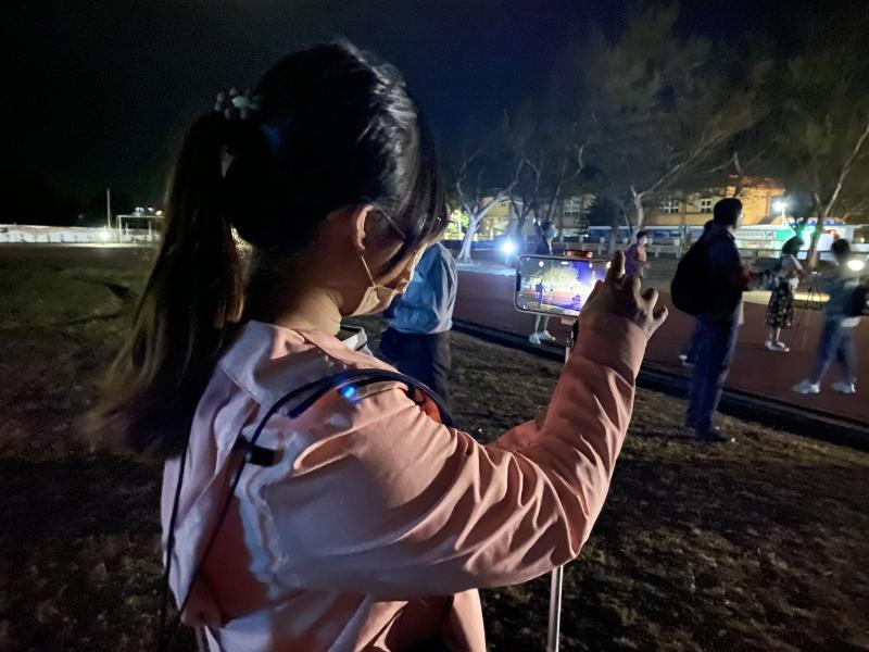 夜間戶外拍攝練習，學員使用手機腳架拍攝夜景