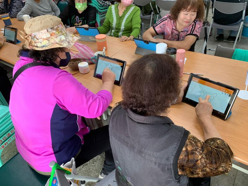 阿公阿嬤在平板開心的畫畫