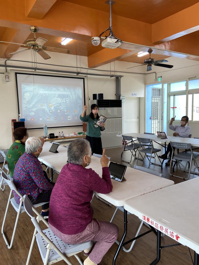 頂寮社區行動DOC，現場大多數的長輩是完全沒有使用過手機、平板等3C產品的，首先老師先教大家如何開機與操作，跟著老師使用一隻手指用摸的就可以操作平板。