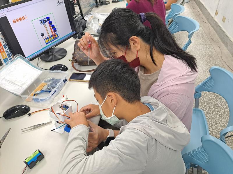 老師教導家長和小朋友下載積木程式並組裝機器人