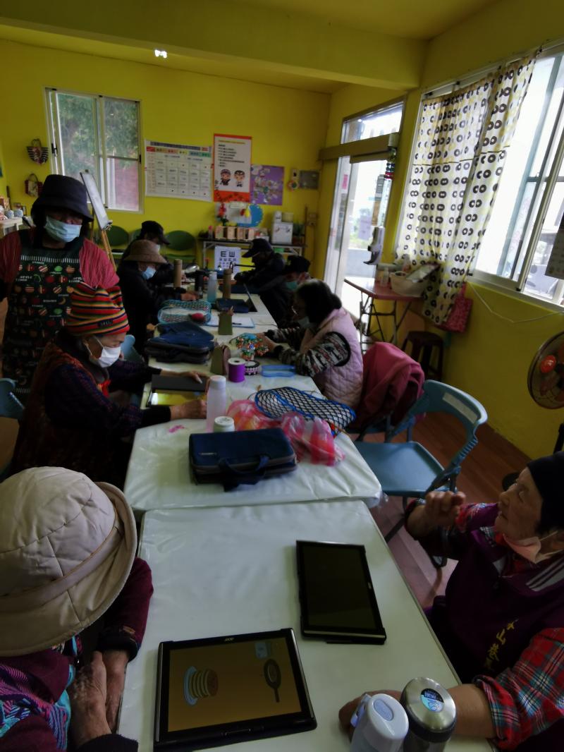 指導老人玩玩小遊戲，讓老人操作數位平板。