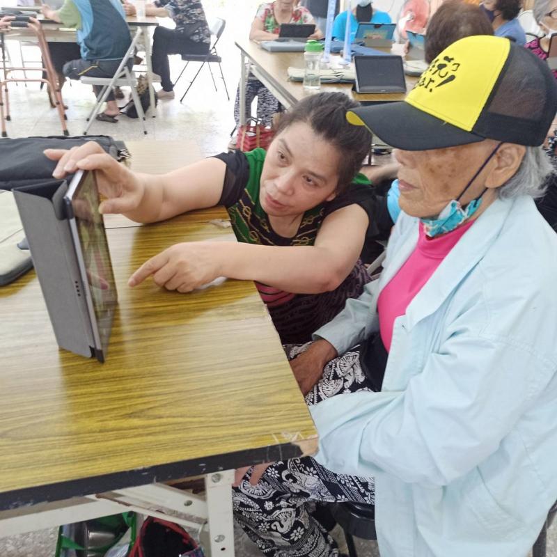 站上服務員協助長者使用平板