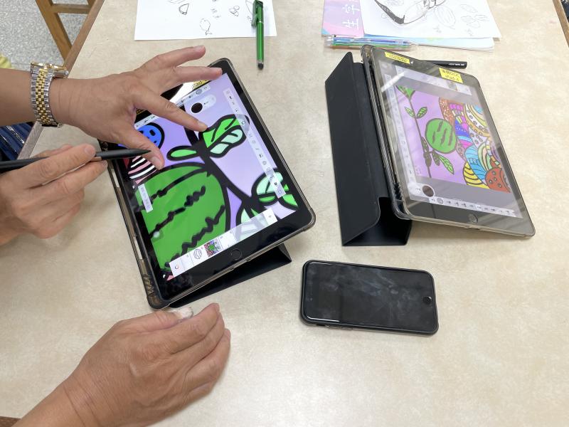 老師耐心教導學員操作平板繪製圖像。