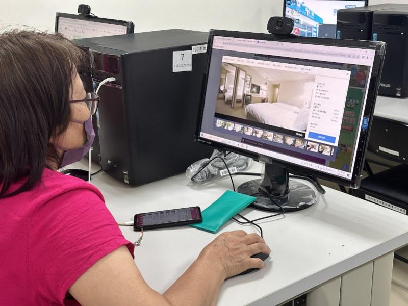 學員利用電腦搜尋飯店