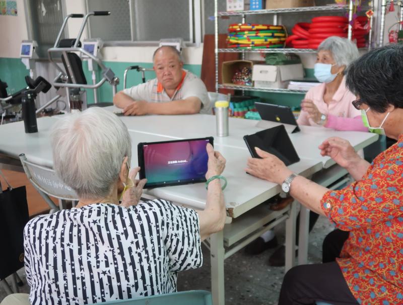 高齡長輩專注學習，透過數位學習，練習用平板照相，必能拍出美美的照片,用平板紀錄生活大小事及旅遊樂趣。