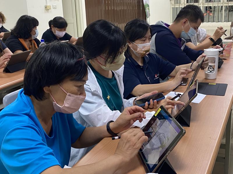 專注在平板上用觸控筆作畫的學員們