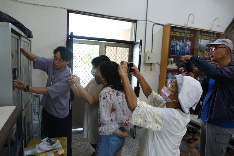 學員提問講師要如何讓玻璃不要反光?  講師親自示範邊說讓鏡頭靠近玻璃並遮住光線就不會反光了。