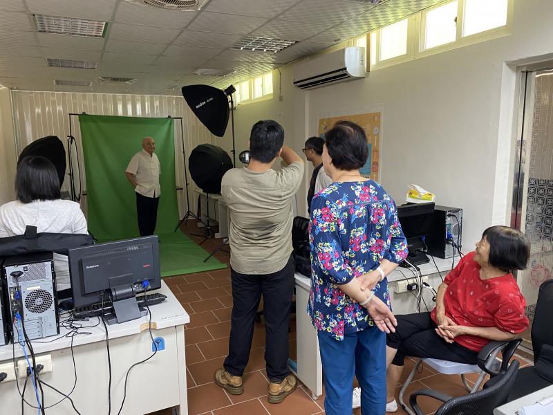 學員們站在攝影師後面，研究攝影師的拍攝器具和拍出來的成果。