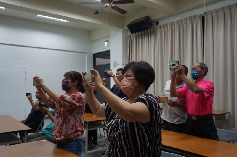 學員拿起手機練習老師教的拍攝方式