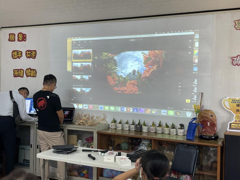 剛剛講師帶每位長輩到外面的花叢，讓長輩拿全景相機自拍