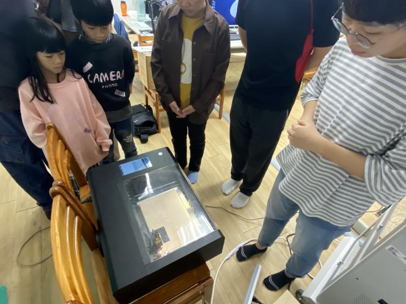 老師與學員進行鐳雕作品的輸出