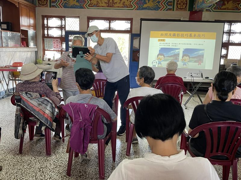 教導長者使用數位平板進行攝影