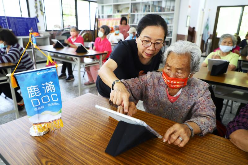 志工協助長輩操作平板電腦